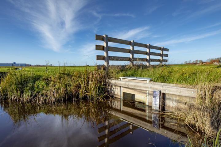 Foto van een kraan die bezig is met het omkeren van de toplaag, de zandlaag en de veenlaag